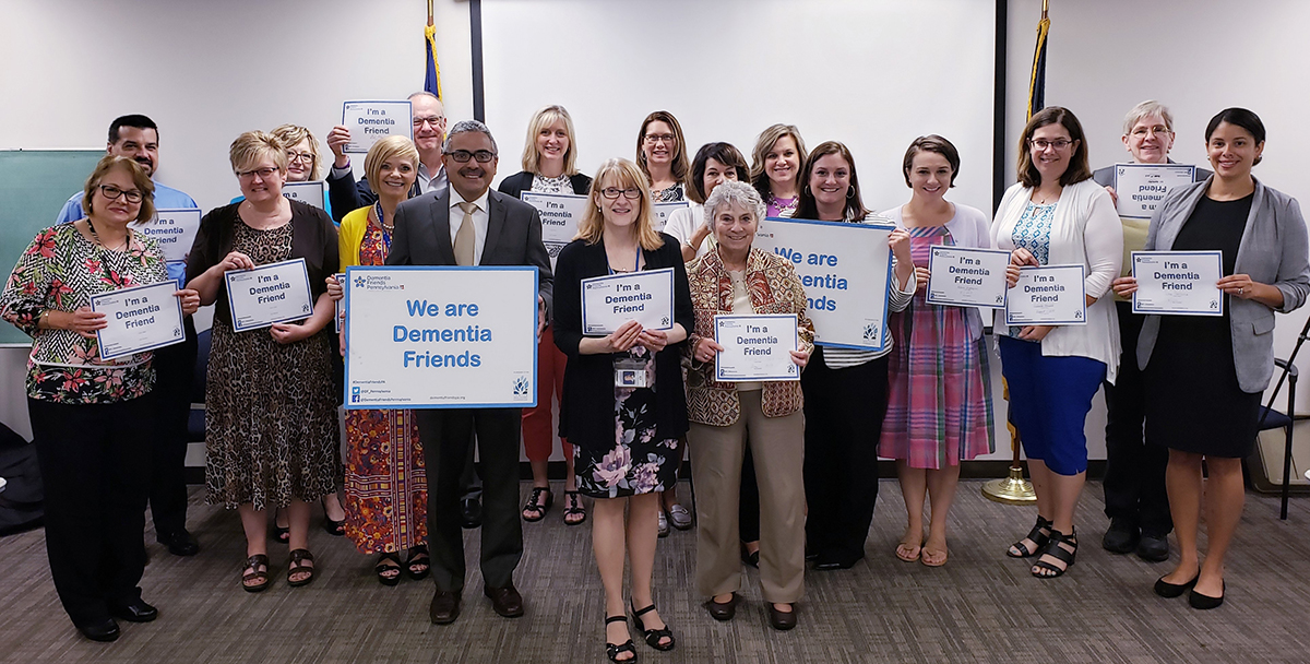 Robert Torres, (center left with large sign) secretary of the state Department of Aging, staffers and members of the Alzheimer’s Disease & Related Disorders State Plan Task Force became Dementia Friends this summer.
