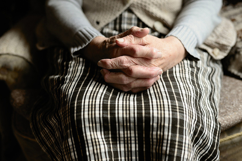 image of an older person's hands sitting folded in their lap