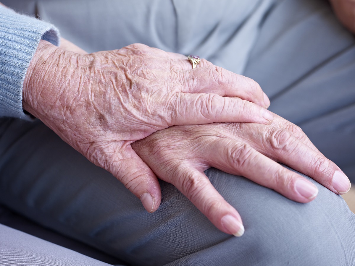 Closeup of two older people holding hands